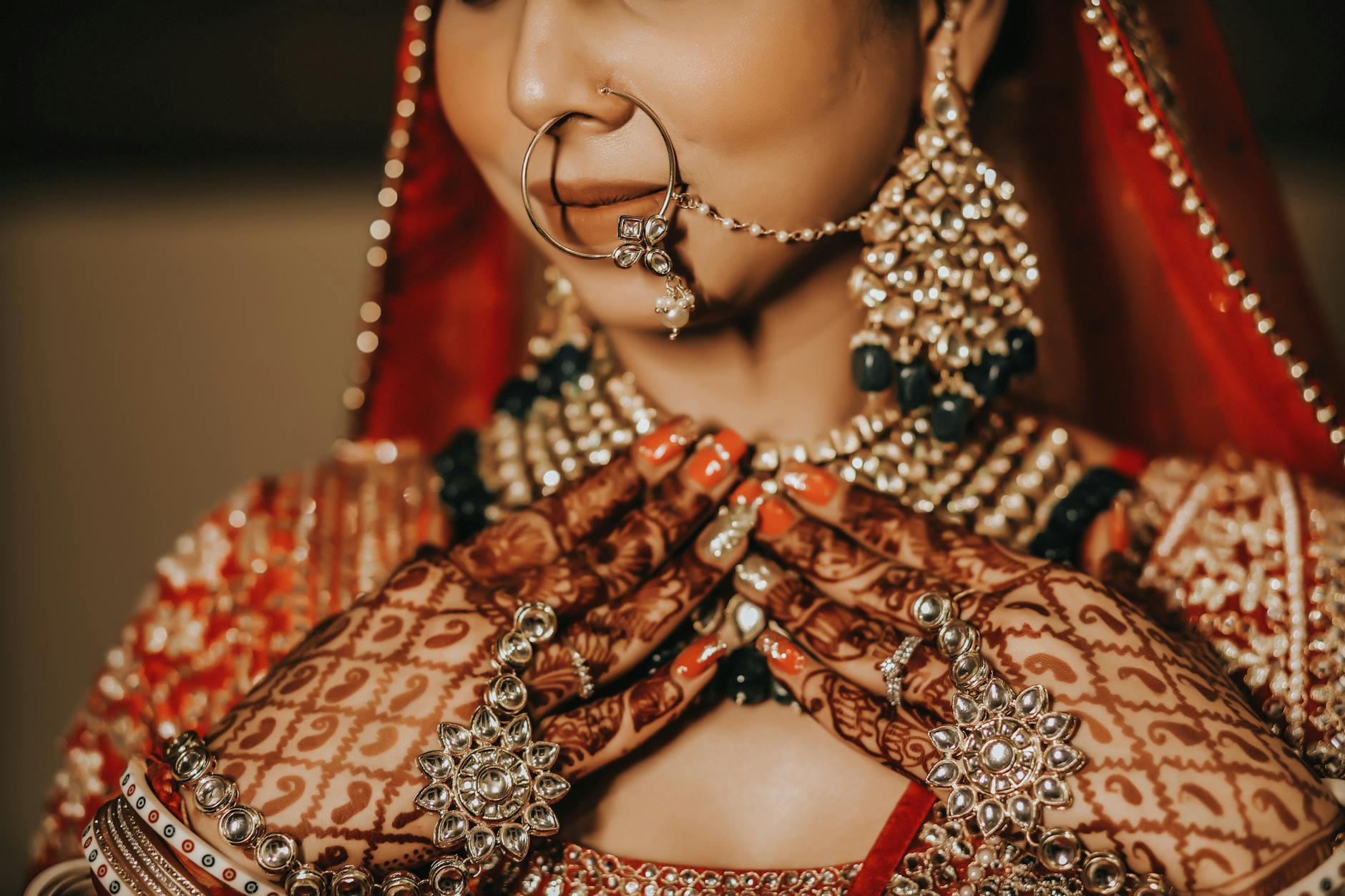 Biżuteria ślubna celebrytek: co wybierają do sukni i jak przenieść to na swój styl Panna młoda w indyjskim stroju ślubnym z bogatą biżuterią i henną